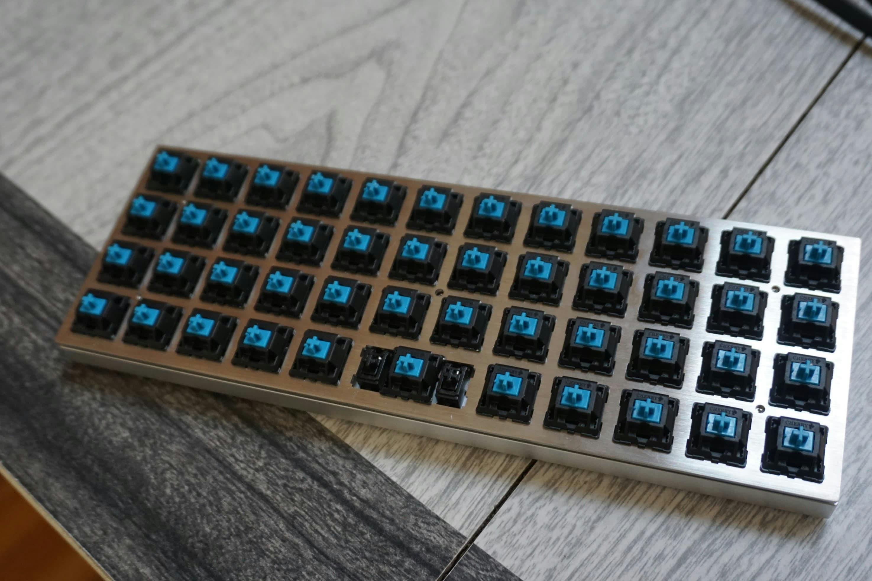 Planck keyboard, Cherry MX blue switches soldered and the top plate sitting in the case. No keycaps yet