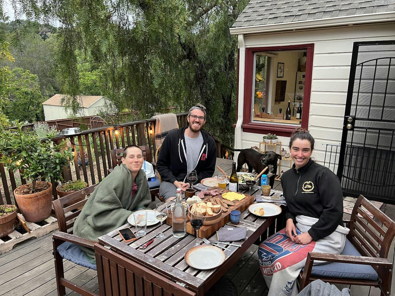 Carla, Mark and Robin sitting outside in Oakland, California around a table